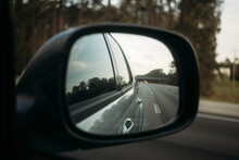 Reflection Of Car On Road Seen In Side-view Mirror