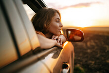 Happy Woman Outstretches Her Arms While Sticking Out The Car Window. Lifestyle, Travel, Tourism, Nature, Active Life.