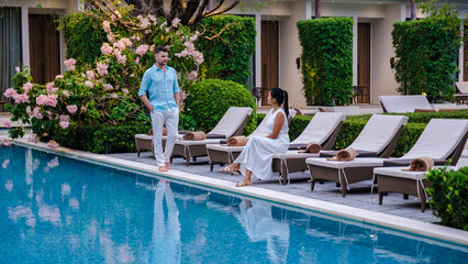 Wall Mural - Luxury 5 star hotel pool in Asia. A couple of men and women on vacation at a luxury hotel resort, men and women by the pool