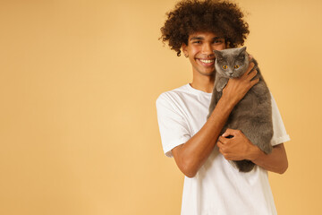 Happy man takes care of his grey cat