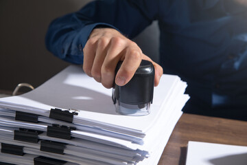 Poster - Businessman puts a stamp on the documents in the office.