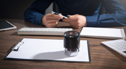 Businessman puts a stamp on the documents in the office.