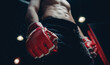 © Parilov - Concept kickboxing sport banner, dark color. Closeup red Gloves for MMA of Boxers fighter in octagon