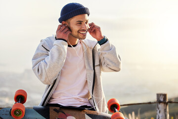 Skateboarder, earphones and man listening to music, audio or podcast online and relax after skating outdoors. Skater, skateboard and person streaming to mobile radio and texting on social media