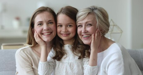 happy sweet daughter kid touching cheeks, faces of mother and senior grandma. little girl, mom, gran