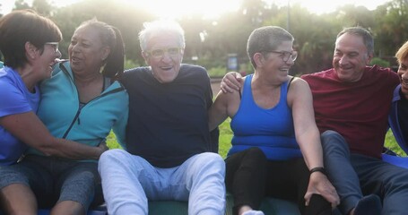 Wall Mural - Multiracial senior people having fun after workout exercises outdoor with city park in background - Healthy lifestyle and joyful elderly lifestyle concept