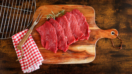 Poster -  plusieurs steaks de bœuf crus, en gros plan, sur une planche à découper