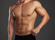 © Siphosethu F/peopleimages.com - Shredded. Cropped shot of an unrecognizable and athletic young man posing shirtless in studio against a dark background.