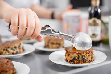 Chef cooks of French restaurant prepares sweet dessert with chocolate and raisins with ice cream