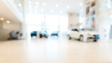 Fototapeta Pomosty - Blurred abstract dealership store, with defocused cars, clients and staff with  soft lightning