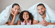 © Lumeez Ismail/peopleimages.com - Relax, happy and girl with her parents in bed for security, love and safety under blanket in their family home. Support, smile and portrait of a child with her mother and father in the bedroom