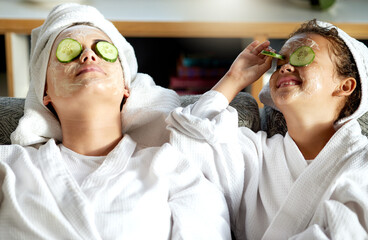 Wall Mural - Happy, carefree and relaxed mother and daughter having a relaxing spa day together. Cheerful, smiling and joyful little girl enjoying a pamper session on the weekend with her mom, nanny or babysitter