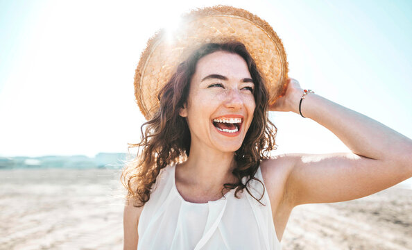 happy beautiful young woman smiling at the beach side - delightful girl enjoying sunny day out - hea