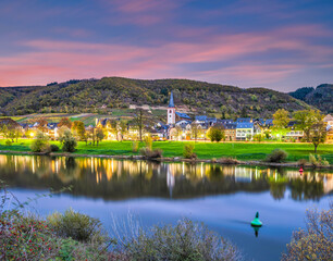 Wall Mural - Long exposure shot of Bruttig-Fankel village on moselle river at dusk during autumna in Cochem-Zell, Germany