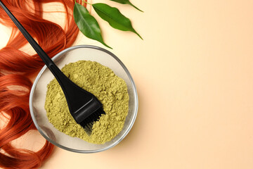 Poster - Bowl of henna powder, brush, green leaves and red strand on beige background, flat lay with space for text. Natural hair coloring