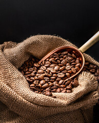 Wall Mural - Scoop of coffee beans in a bag on dark board. Ground coffee in a cup and instant coffee in a wooden cup. Place for text.