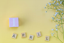 Soft Pink Color Wooden Letters  Shows The Date April 1 ,april Fool Day , Isolated On Yellow Background With Little White Flowers And Copy Space