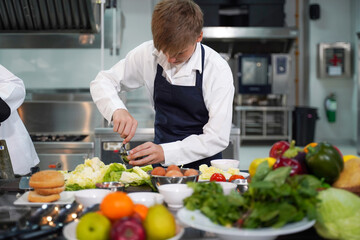 Wall Mural - Chef teacher teaches cooking to the group children in class kitchen room.  Chef preparing student for learning marking and cooking food at workshop.  Education Concept