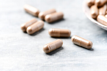 guarana capsules. bright wooden background. close up. copy space.