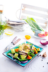 Poster - Green vegan salad with cucumber and avocado on a concrete table. View from above.