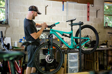 Mechanic Repairing Mountain Bike In Bicycle Shop