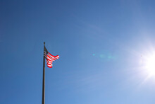 Low Angle View Of American Flag Against Clear Blue Sky During Sunny Day