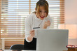 © saltdium - Excited young woman holding credit card and looking at laptop screen. Cashback, big sale and shopping offer concept.