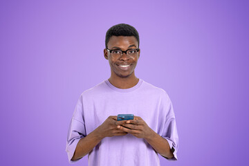 Sticker - African man with smartphone in hands on copy space purple backgr