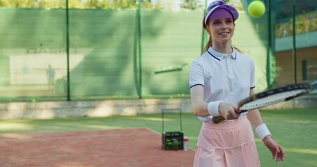 Wall Mural - caucasian happy red-haired female tennis player holding racket and bouncing ball. professional tennis training, sport and competition concept. ball is falling, girl is sad, angry unhappy slow motion