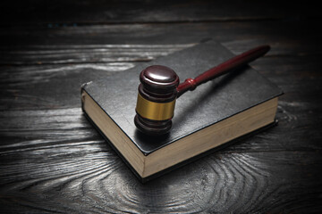 Wall Mural - Judge gavel and book on the black table.