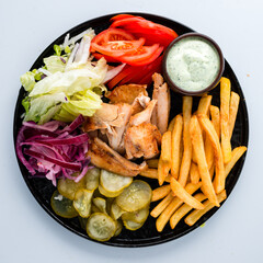 Wall Mural - Fresh french fries with chicken, tomatoes, lettuce, pickled cucumbers and sauce.