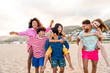 Multiethnic group of happy friends bonding and having fun at the beach on summer vacation - Multiracial real authentic people spending time together at the sea, concepts about youth and summertime
