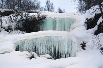 Poster - Beautiful frozen waterfall in mountains on north coast of lake Torneträsk (Tornestrask) around Abisko National Park (Abisko nationalpark). Sweden, Arctic Circle, Swedish Lapland