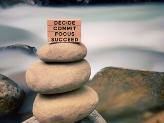 Wall Mural - Inspirational and motivational words of decide commit focus succeed on wooden blocks with vintage background.