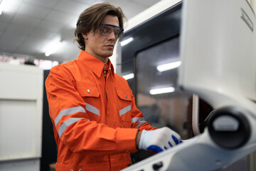 Caucasian engineer man control turning lath machine on monitor at factory