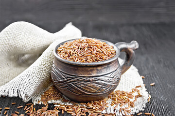 Poster - Rice red in cup on dark wooden board