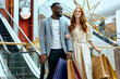 © Roman - awesomen ginger girl and stylish handsome african guy doing shopping together at modern shopping mall. close up portrait. lifestyle, hobby, interests,fashion