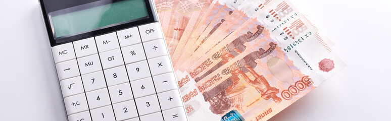 Russian rubles five thousandth banknotes, calculator and stack of money on white background