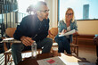 © Flamingo Images - Two smiling businesspeople meeting with colleagues in a modern office