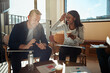 © Flamingo Images - Two diverse business colleagues laughing during an office meeting