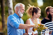 © Flamingo Images - Man pouring friends wine outside