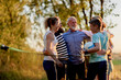 © Flamingo Images - Laughing family hugging after volleyball
