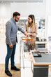 © Dusko - Elegant middle age businessman choosing and buying his new expensive watch. Beautiful young female seller helps him to make good decision. Fashion style and elegance concept.
