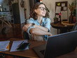 © olezzo - Happy creative young woman in eyeglasses working on laptop at home. Remote work, small business and freelancing concept