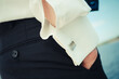 Man`s hand in pockets with white dress shirt and cufflink up close