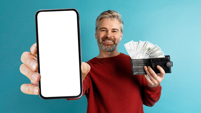 Wall Mural - Happy middle aged man showing cell phone and cash