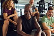 © Flamingo Images - Smiling friends sitting on steps in a gym
