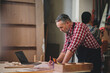 © DJ Creative Studio - Professional senior cauasian man working woodworking handmade with tools in wood workshop, Timber factory industry.