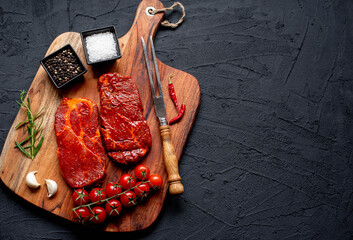 Wall Mural - marinated raw pork steaks on stone background with copy space for your text