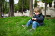 © MNStudio - Cute toddler boy playing in the grass in Bergamo. Little child having fun exploring in Citta Alta, upper district of Bergamo. Bergamo, Italy.